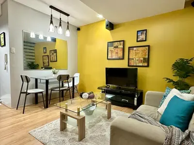 a living room with a couch and a table at Spacious 1BR Condo with 300mbps WiFi in BGC in Manila
