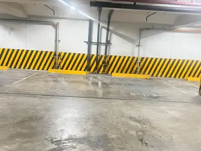 an empty parking garage with yellow and black barricades at R&R Empire Rental Unit in Manila