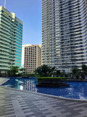 a large swimming pool in a city with tall buildings at Air Residences in Manila