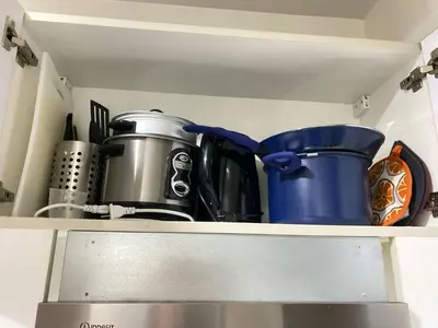 a shelf with pots and pans in a kitchen at Air Residences in Manila