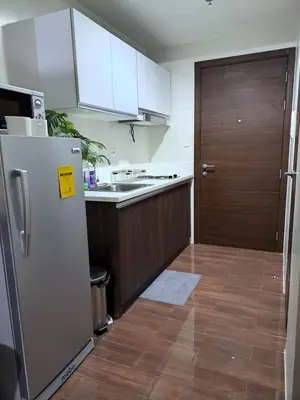 a kitchen with a refrigerator and a wooden door at Air Residences in Manila