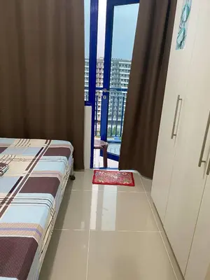 a bedroom with a bed and a view of a city at Janas Condotel in Manila