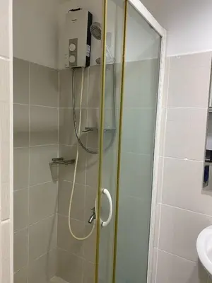 a shower with a glass door in a bathroom at Janas Condotel in Manila