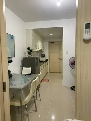 a kitchen with a table and chairs and a table and a kitchen at Janas Condotel in Manila