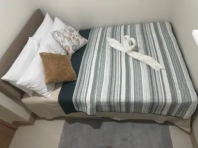 a bed with a striped sheet and a white ribbon at Casa De Ciudad - Shore Residences MOA PASAY in Manila
