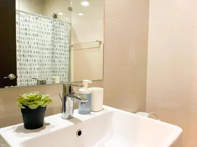 a white bathroom with a sink and a mirror at Prime 1BR Condo in the Heart of BGC #upt12j in Manila
