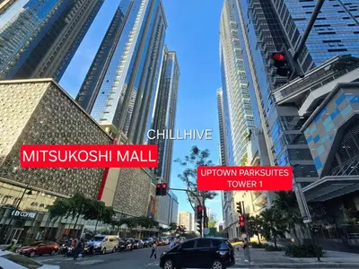 a busy city street with tall buildings and street signs at Prime Uptown BGC | Stylish 1BR Getaway #upt1 35j in Manila