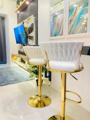 a living room with a white chair and a tv at Casa Cion Staycation in Manila