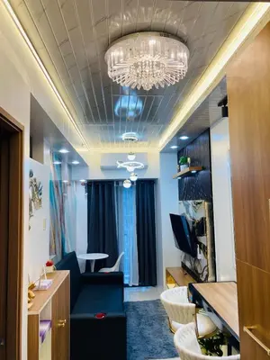 a living room with a blue couch and a chandelier at Casa Cion Staycation in Manila