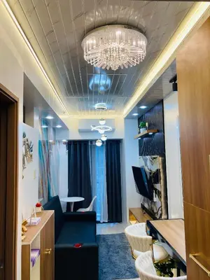 a living room with a blue couch and a chandelier at Casa Cion Staycation in Manila