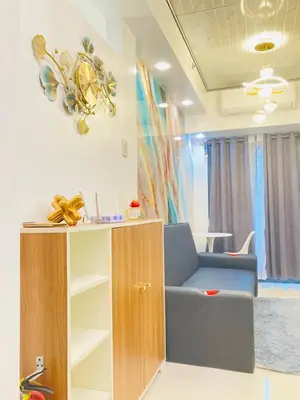 a living room with a chair and a cabinet at Casa Cion Staycation in Manila