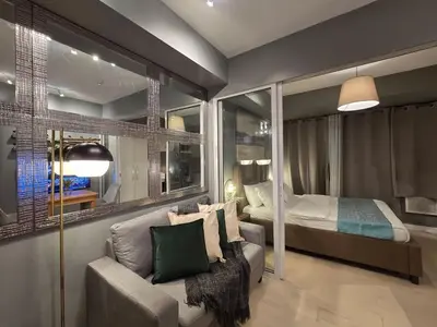 a bedroom with a bed and a couch in front of a bed at 1BR Condotel at Azure Urban Resort Near Airport #AZ07 in Manila