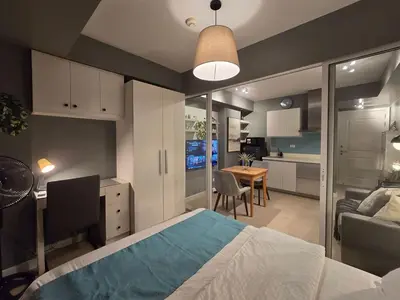 a bedroom with a bed and a desk and a kitchen at 1BR Condotel at Azure Urban Resort Near Airport #AZ07 in Manila