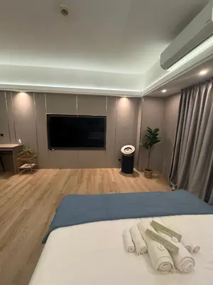 a room with a bed and a flat screen tv at Venice Luxe Stay, Studio Type, King Bed, 65 TV-Netflix 40\u5e73\u65b9\u56db\u4eba\u516c\u5bd3 \u53a8\u5177\u9f50\u5168 in Manila
