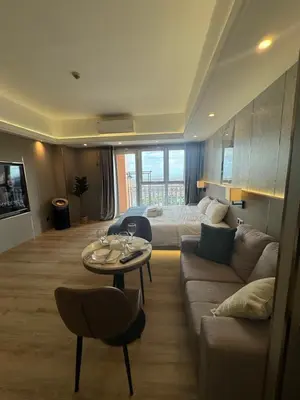 a living room with a couch and a table at Venice Luxe Stay, Studio Type, King Bed, 65 TV-Netflix 40\u5e73\u65b9\u56db\u4eba\u516c\u5bd3 \u53a8\u5177\u9f50\u5168 in Manila