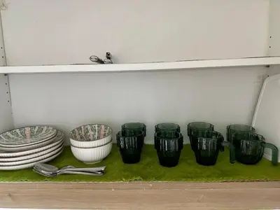 a row of green cups and plates on a shelf at Avocado Room near MOA PICC 2 BEDS in Manila