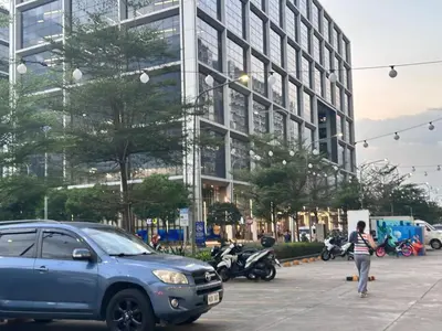 a woman walking in a parking lot next to a building at Avocado Room near MOA PICC 2 BEDS in Manila