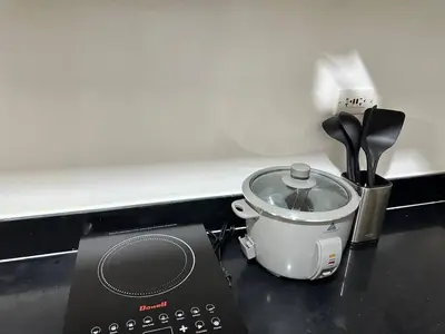 a kitchen counter with a slow cooker and a toaster at Avocado Room near MOA PICC 2 BEDS in Manila