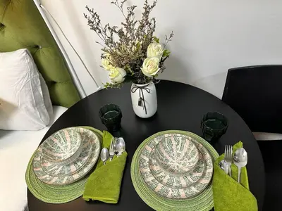 a black table with two plates and a vase with flowers at Avocado Room near MOA PICC 2 BEDS in Manila