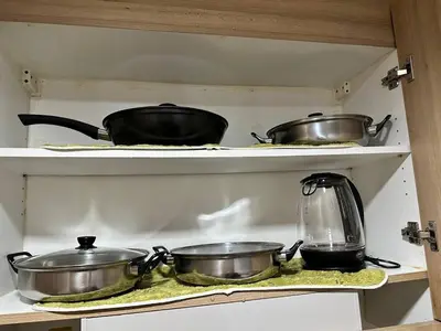 three pots and pans on a shelf in a kitchen at Avocado Room near MOA PICC 2 BEDS in Manila