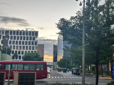 a red bus driving down a city street with buildings at Avocado Room near MOA PICC 2 BEDS in Manila