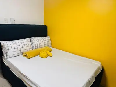 a bed with two yellow pillows on top of it at Mango Room near MOA STARCITY 2 Beds in Manila