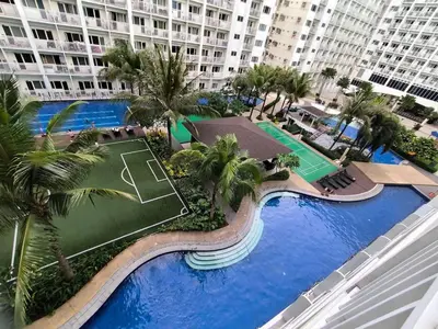 an overhead view of a swimming pool with palm trees and buildings at Mango Room near MOA STARCITY 2 Beds in Manila