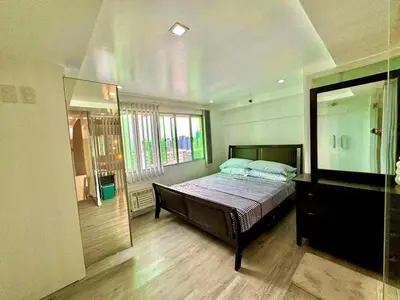 a bedroom with a bed and a large mirror at Entire Condo loft in Mandaluyong in Manila