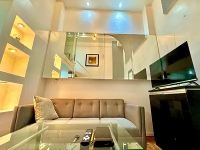 a living room with a couch and a glass table at Entire Condo loft in Mandaluyong in Manila