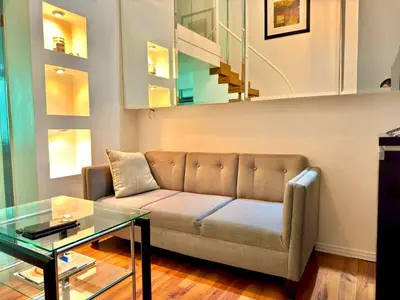 a living room with a couch and a glass table at Entire Condo loft in Mandaluyong in Manila