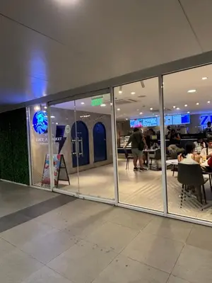 a restaurant with glass doors and people sitting at tables at Shell Residences Near Moa and Naia Airport- Rhoi in Manila