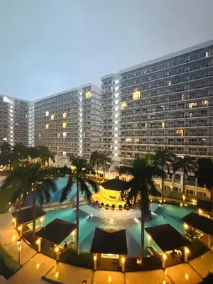 a large building with a large pool in front of it at Shell Residences Near Moa and Naia Airport- Rhoi in Manila