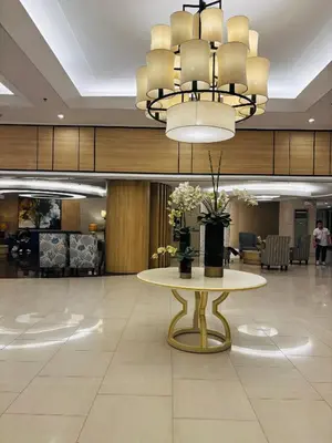 a lobby with a table and a chandelier at Shell Residences Near Moa and Naia Airport- Rhoi in Manila