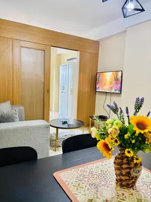 a living room with a vase of flowers on a table at Shell Residences Near Moa and Naia Airport- Rhoi in Manila