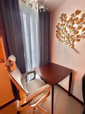 a chair and a table in a room with a window at Condo in Ermita near UP-PGH, St Lukes & US Embassy in Manila