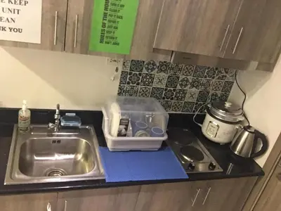 a kitchen counter with a sink next to a sink at KakaI's Staycation in Fame in Manila