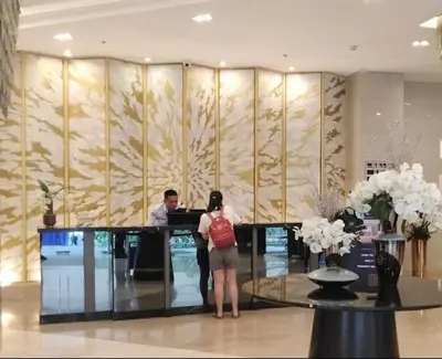 a woman standing in front of a counter in a lobby at KakaI's Staycation in Fame in Manila