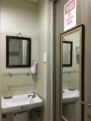 a bathroom with two sinks and a mirror at KakaI's Staycation in Fame in Manila