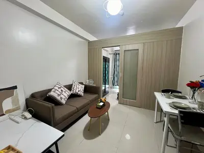 a living room with a couch and a table at Shore residences A 1br Near SM MOA in Manila