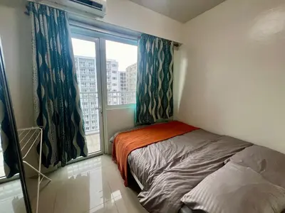 a small bedroom with a bed and a window at Shore residences A 1br Near SM MOA in Manila