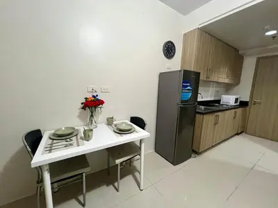 a small kitchen with a table and a refrigerator at Shore residences A 1br Near SM MOA in Manila