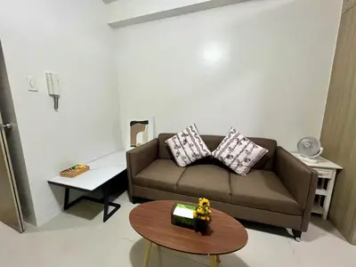 a living room with a couch and a table at Shore residences A 1br Near SM MOA in Manila