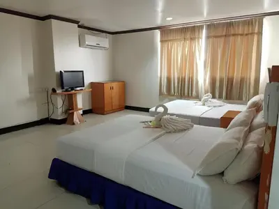 a hotel room with two beds and a television at Jeamco Royal Hotel - Pasig in Manila