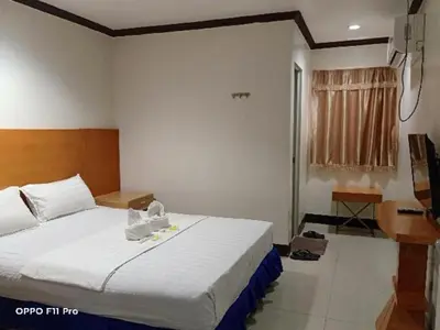 a bedroom with a large bed and a desk at Jeamco Royal Hotel - Pasig in Manila