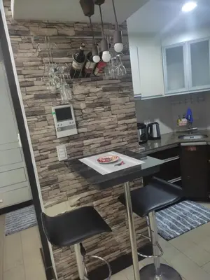 a kitchen with a stone wall with a table and chairs at LDN Staycation Booking partners in Manila