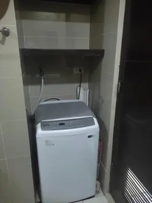 a washer and dryer in a room with a wall at LDN Staycation Booking partners in Manila