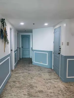 an empty hallway with blue doors and a tile floor at Whole Ocean View Manila Bay 4 Bedrooms in Manila