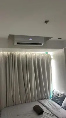 a bed in a room with a window with white curtains at Whole Ocean View Manila Bay 4 Bedrooms in Manila