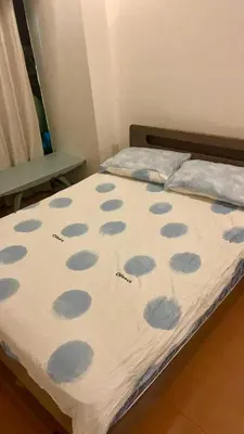 a bed with a blanket with blue spots on it at Whole Ocean View Manila Bay 4 Bedrooms in Manila