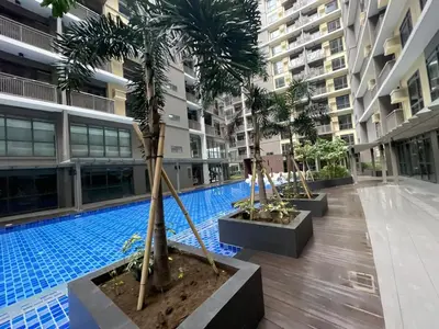 a swimming pool in the middle of a building with palm trees at Modern & Luxury 1BR near Okada, Solaire, Airport in Manila